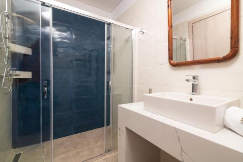 a bathroom with a sink and a glass shower at Astarte Villas - Coral Bleu Villa with Private Pool in Tsilivi