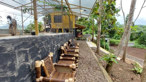 una fila di panche di legno sedute su un muro di Delta Island Camping Ground a Sumedang