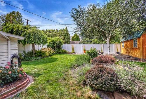 a yard with a white fence and a yard with a yard at Centrally located, family and furry friendly fun! in Yakima