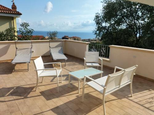 - un ensemble de chaises et d'une table sur une terrasse dans l'établissement Appartamenti MiNuMa Tropea, à Tropea