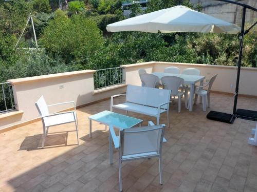 d'une terrasse avec des tables, des chaises et un parasol. dans l'établissement Appartamenti MiNuMa Tropea, à Tropea