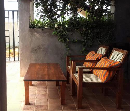 a table and two chairs and a table and a bench at Takimi Mini Villa in Wellawaya