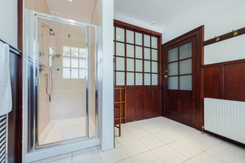 a bathroom with a walk in shower and a glass door at Newholme House in Stirling