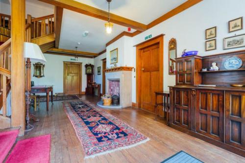 a large living room with a table and a fireplace at Newholme House in Stirling