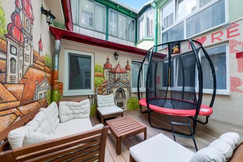 a patio with a couch and a swing on a building at Revelton Studios Prague in Prague