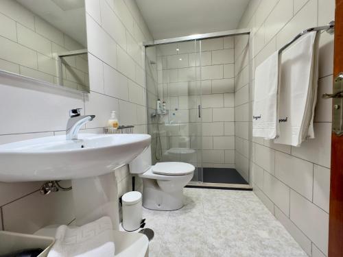 uma casa de banho branca com um lavatório e um WC em apartment arrecife beyond em Arrecife