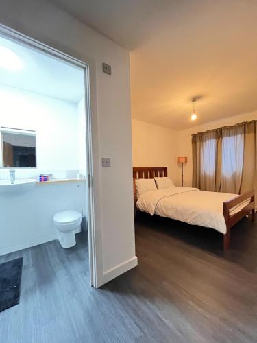 a bedroom with two beds and a tub and a toilet at Spacious London apartment 5 min walk to Leytonstone Underground Station and 5 stops to zone 1 in London