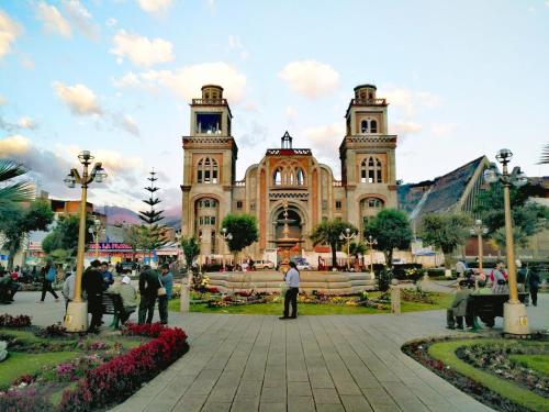 a large building with two towers with people in front of it at Hotel Valery II in Huaraz