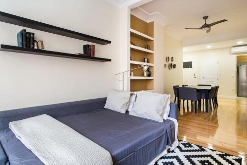 a living room with a blue couch and a dining room at Athena's Nest- *best Location* A/C +HEAT! in Athens