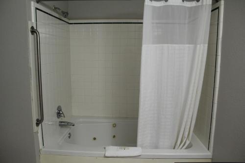 a bathroom with a bath tub with a shower curtain at Quality Inn Crossville Near Cumberland Mountain State Park in Crossville