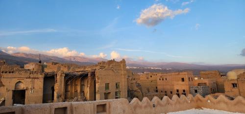 a group of buildings with mountains in the background at Bait Al Aali Guesthouse in Al Ḩamrāʼ
