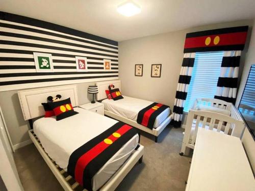 um quarto com 2 camas e um berço em Modern 4 Bedrooms Vacation Home with Splash Pool at Le Reve Resort (4435) em Kissimmee