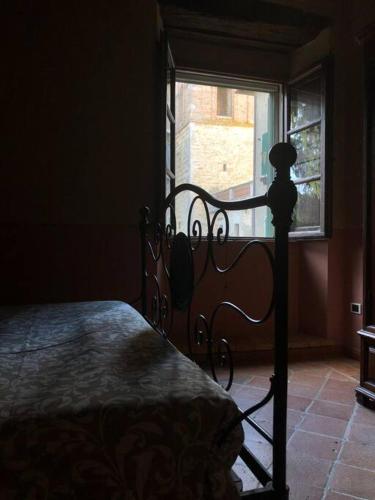 łóżko w sypialni z oknem w pokoju w obiekcie Casa Amiata w mieście Sarteano