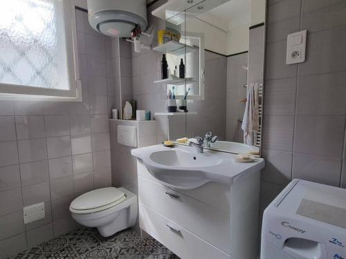 une salle de bain blanche avec des toilettes et un lavabo dans l'établissement Appartement T2 RDC à 100m de la plage avec terrasse et jardinet - 4 couchages - FR-1-388-1, à Argelès-sur-Mer
