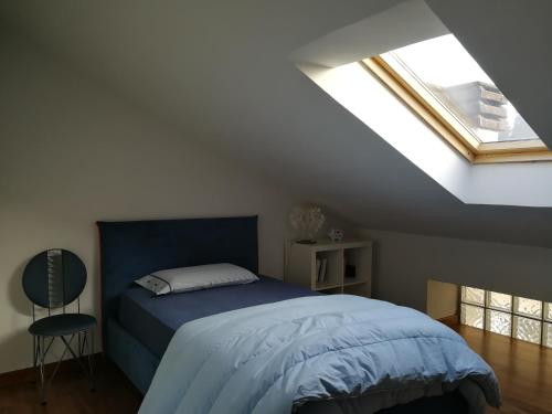 a bedroom with a blue bed and a window at Villa in Precollina in Turin