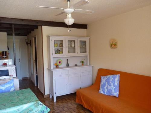 un salon avec un canapé orange et une armoire blanche dans l'établissement Appartement T2 avec Piscine, Ascenseur et Parking Privé, à 300m de la Plage - 4 Couchages, Animaux OK - FR-1-388-89, à Argelès-sur-Mer