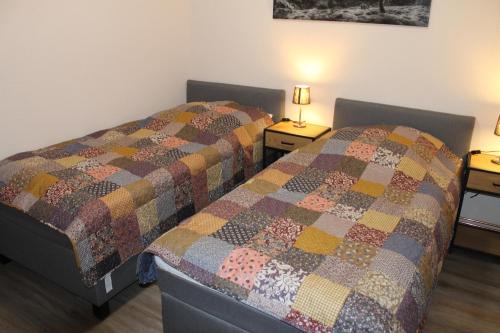 dwa łóżka w pokoju z dwoma lampami na stołach w obiekcie Ferienwohnung Krümel w mieście Emden