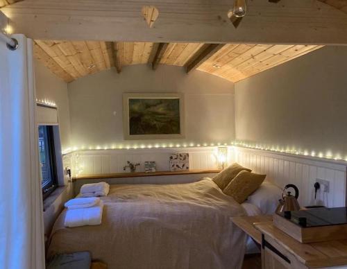 a bedroom with a bed with lights on it at Aspen Leaves: The perfect farm retreat in Graffham