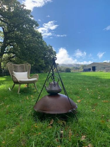 a tea pot and a chair in a field at Aspen Leaves: The perfect farm retreat in Graffham