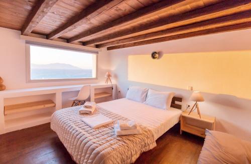a bedroom with a bed and a large window at Villa Phaedra by Whitelist Mykonos in Agios Ioannis Mykonos