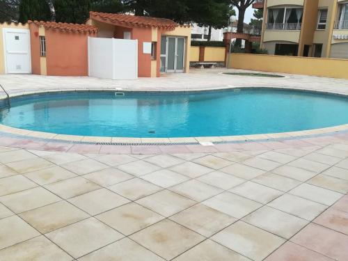 une piscine dans une cour avec un bâtiment dans l'établissement Studio cabine avec piscine, parking privé, proche plage - Argelès-sur-Mer - FR-1-388-188, à Argelès-sur-Mer