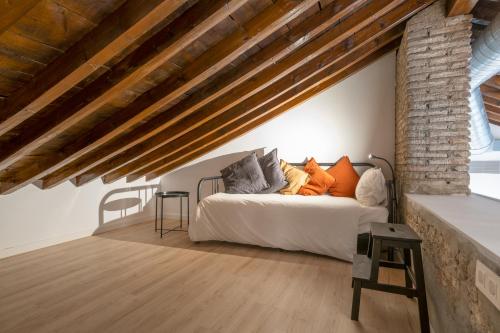 een slaapkamer met een bed en een bakstenen muur bij Apartamentos Málaga Centro El Conde by Renthas in Málaga