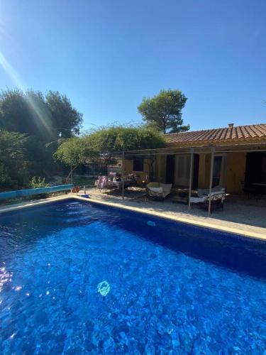 uma grande piscina em frente a uma casa em Villa piscine et climatisation em Sauveterre