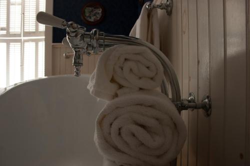 a pile of towels hanging from a bath tub at Camden Windward House in Camden