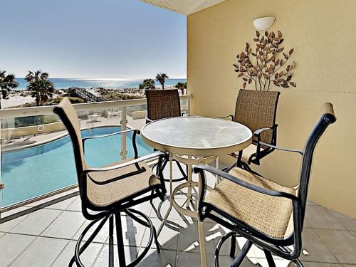 a table and chairs on a balcony with a view of the ocean at Emerald Isle #103 in Pensacola Beach