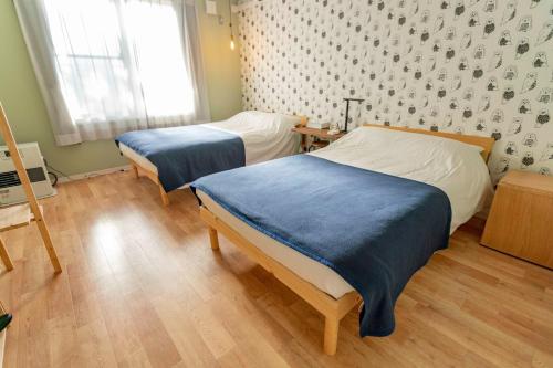 Zimmer mit 2 Betten in einem Zimmer mit Fenster in der Unterkunft Sarabetsu-mura chiiki Kouryu Center - Vacation STAY 35300v in Naka-satsunai
