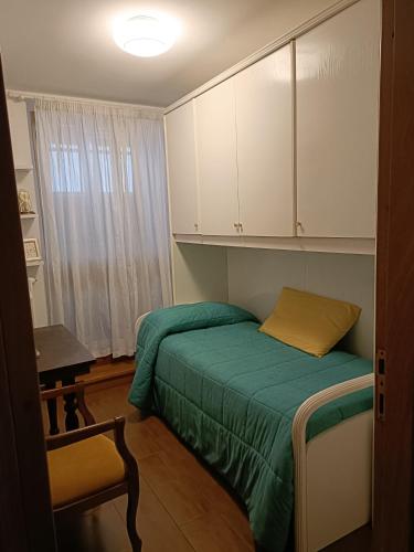 una piccola camera con letto verde e armadi bianchi di Casa Elisabetta a Fano