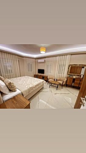 Cette chambre comprend un lit, une table et des chaises. dans l'établissement Hasanbey Apart Otel, à Belek