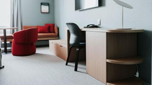 um quarto com uma secretária, uma cadeira e um sofá em Haworth Hotel at Hope College em Holland