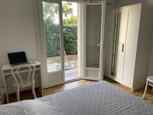 une chambre avec un lit et un bureau avec un ordinateur portable dans l'établissement Vacances entre Bormes et Le Lavandou, à Bormes-les-Mimosas
