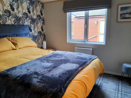 a bedroom with a large bed and a window at Sycamore Lodge Auchterarder in Auchterarder