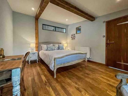 a bedroom with a bed and a wooden floor at The Nutshell. Rural retreat in Pluckley