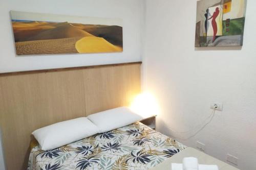 una piccola camera da letto con un letto con copriletto bianco di koka terraced accommodation a Maspalomas