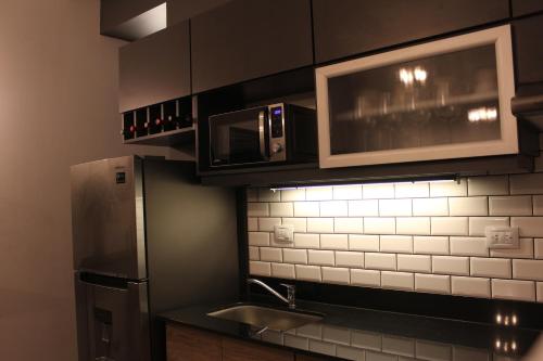 a kitchen with a stainless steel refrigerator and microwave at Luminoso y acogedor apartamento in San Juan