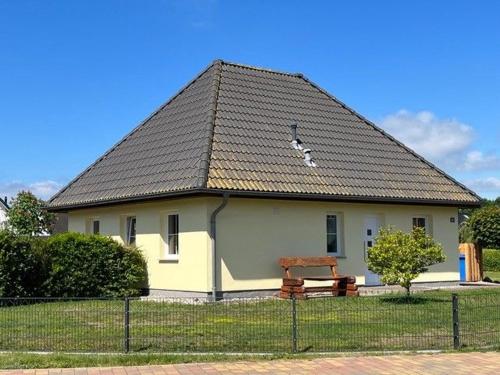 a white house with a black roof and a bench at Haus am NSG Baaber Heide in Baabe