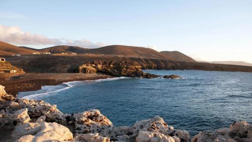 a view of a beach with rocks and the ocean at Apartamento Joshualba in Mesquer
