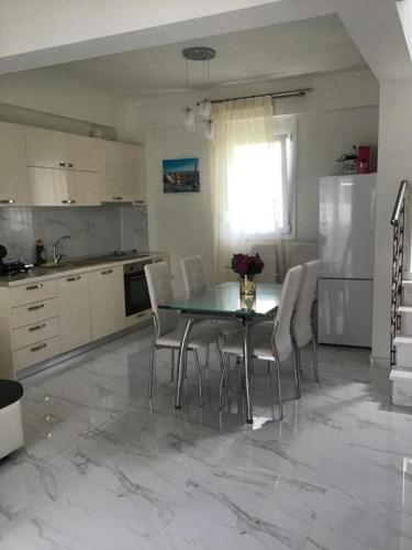 a kitchen with a table with chairs and a refrigerator at Natalia House in Nikiti