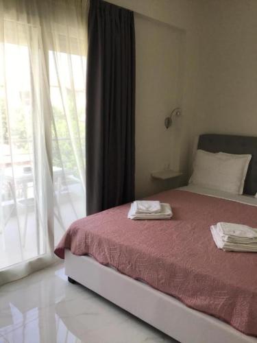 a bedroom with a bed and a large window at Natalia House in Nikiti