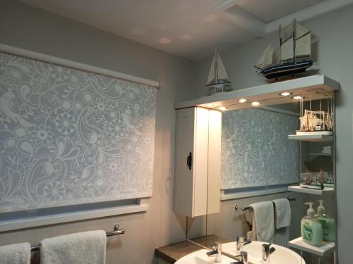 a bathroom with a sink and a mirror at Coastguard Cottage in Newcastle