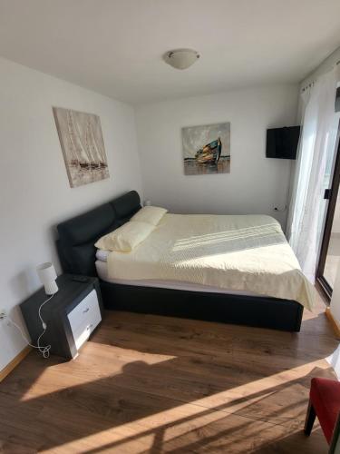 Schlafzimmer mit einem Bett, einem Schreibtisch und einem Fenster in der Unterkunft Apartment Stipe in Bibinje