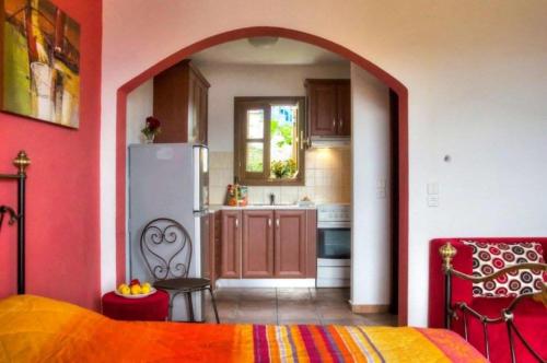 a kitchen with an archway into a kitchen with a refrigerator at Anatoli Residences in Alonnisos Old Town