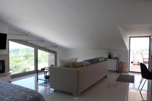a white living room with a couch and a bed at ASSINI View in Asíni