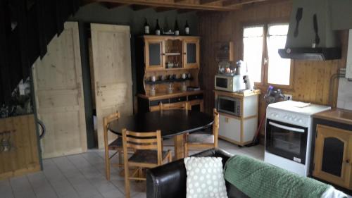 une cuisine avec une table et une cuisine avec une cuisinière dans l'établissement CHALET BORD DE MER, à Lingreville