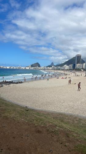 un groupe de personnes sur une plage près de l'océan dans l'établissement Quartinho Copacabana-Posto 5, à Rio de Janeiro