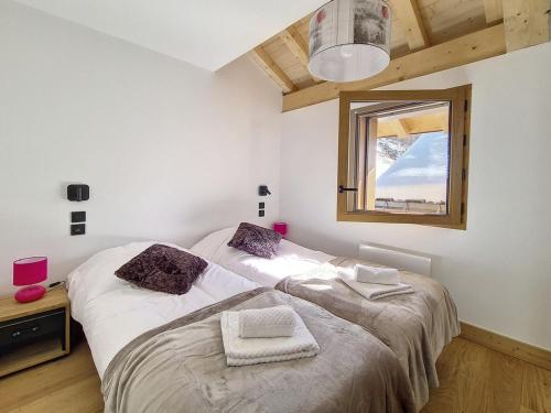 una camera da letto con due letti e una finestra di Chalet moderne avec sauna près des pistes - FR-1-344-1160 a Praranger