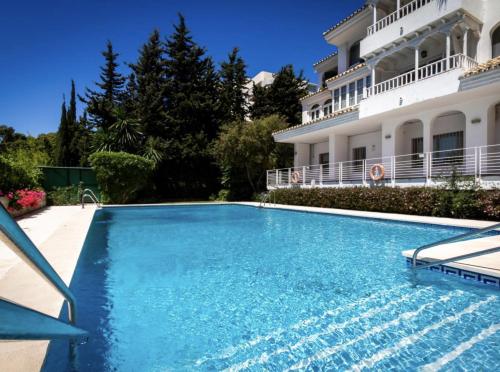 a swimming pool in front of a building at Apartamento Puerto Banus in Marbella
